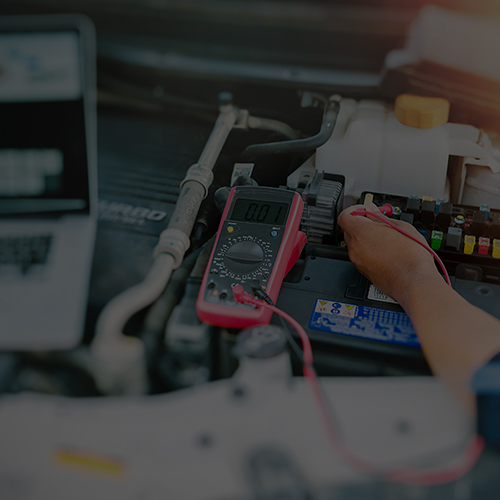 Close up of auto mechanic jumping battery car.